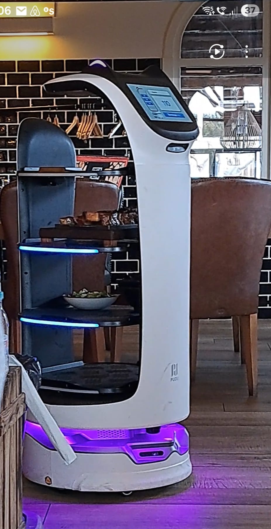 Robot de servicio junto a las mesas de un restaurante