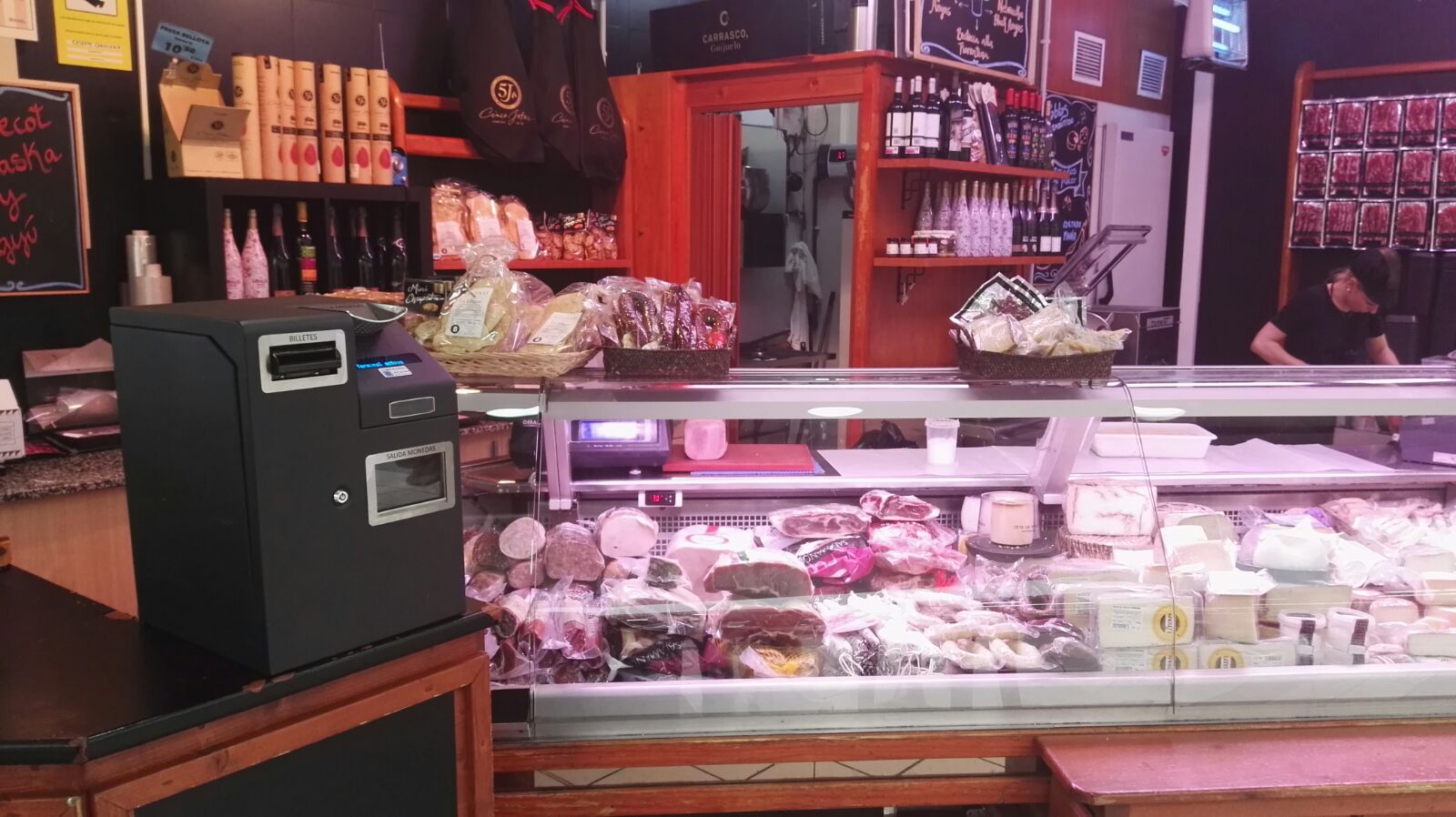 CashKeeper i vitrina de productes frescos en un comerç d’alimentació