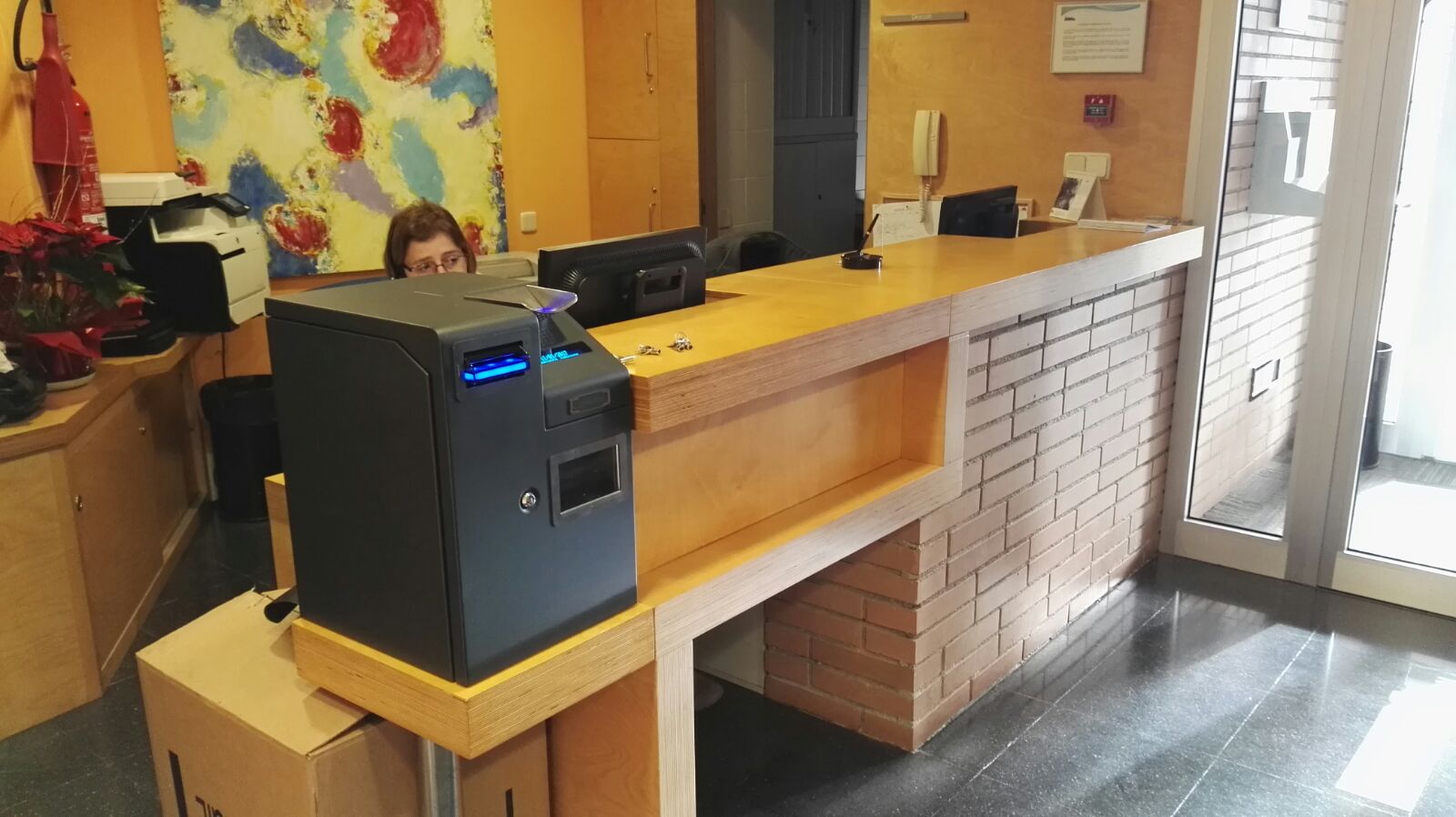CashKeeper al costat del taulell de recepció d’un negoci de serveis